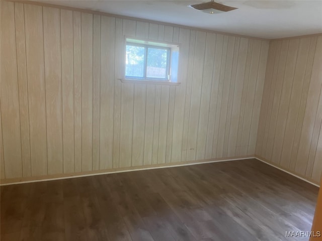 empty room featuring wood walls and dark hardwood / wood-style floors