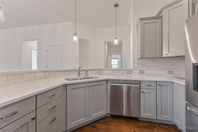 kitchen featuring sink, backsplash, gray cabinets, and appliances with stainless steel finishes