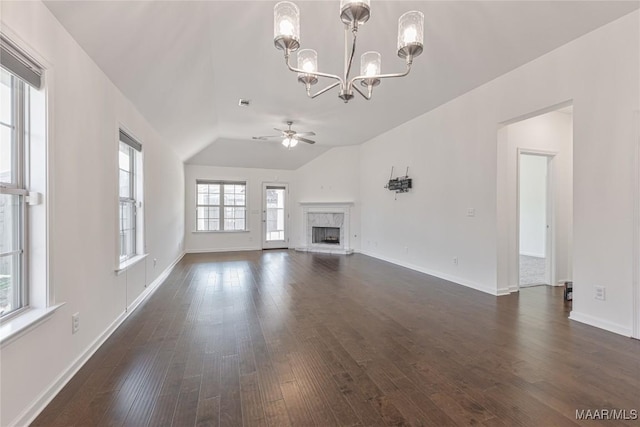 unfurnished living room with lofted ceiling, dark hardwood / wood-style floors, and ceiling fan with notable chandelier