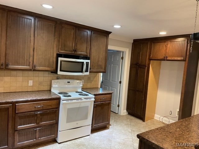 kitchen with tasteful backsplash, light tile patterned floors, and electric range