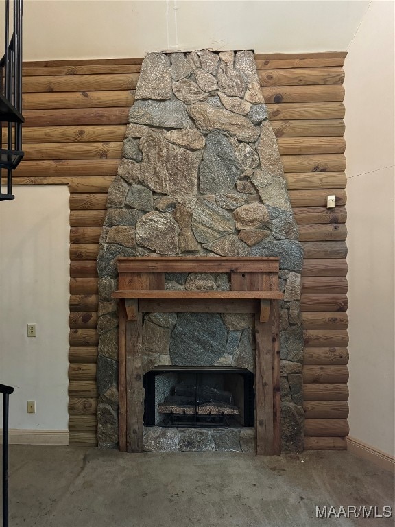 details with a stone fireplace and log walls