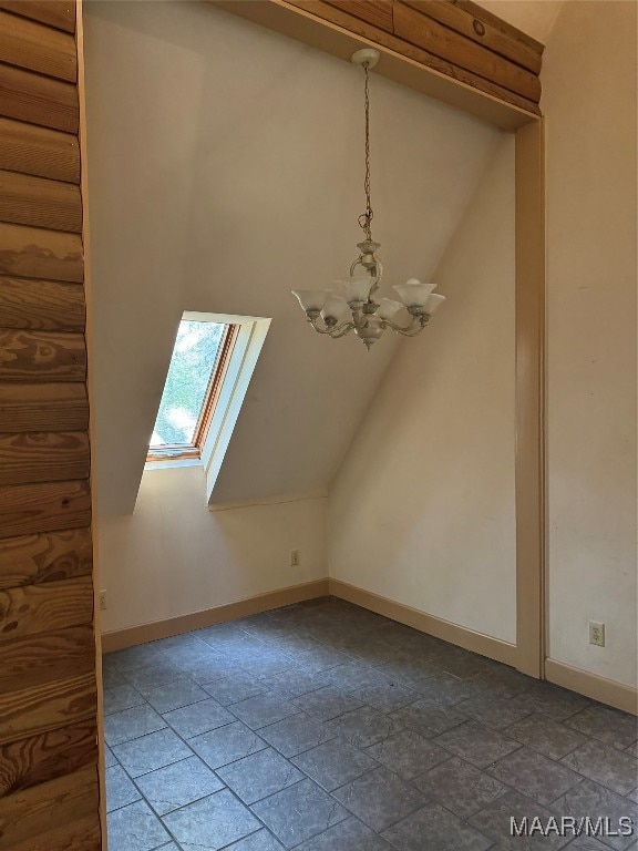 bonus room with a skylight and a notable chandelier