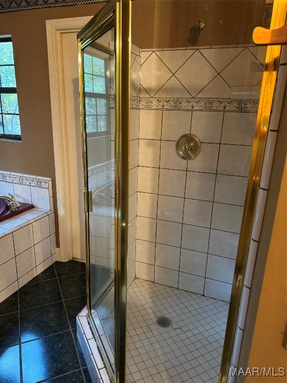 bathroom with tile patterned flooring, a wealth of natural light, and independent shower and bath