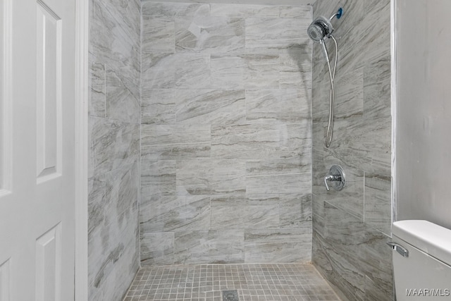 bathroom with toilet and a tile shower