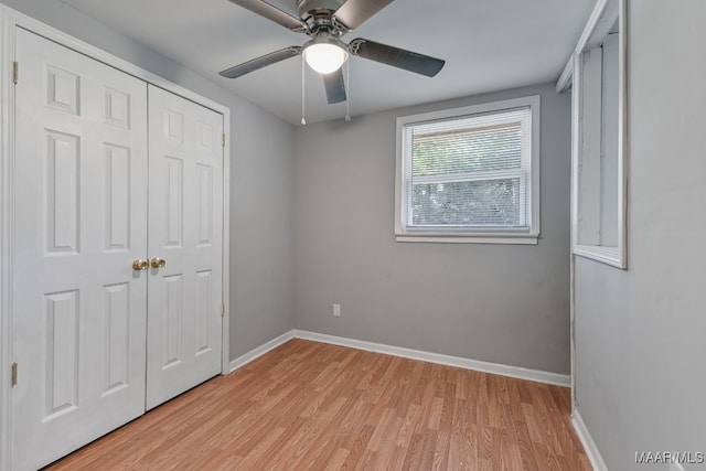 unfurnished bedroom featuring light wood-type flooring, ceiling fan, and a closet