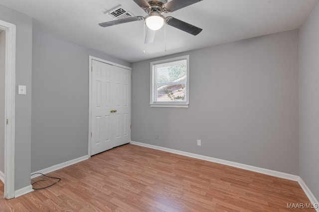 unfurnished bedroom with a closet, light hardwood / wood-style floors, and ceiling fan