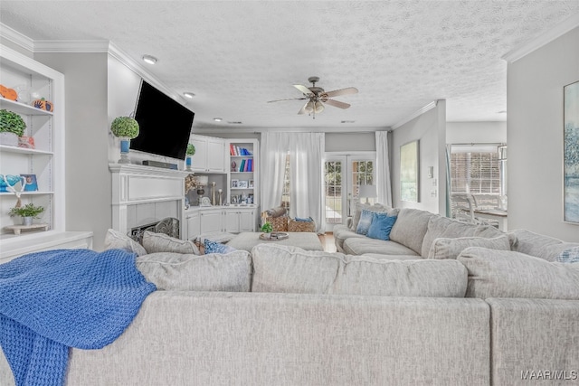 living room featuring ceiling fan, a textured ceiling, and crown molding