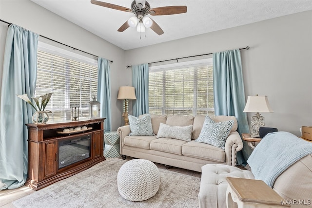 living room with a healthy amount of sunlight, ceiling fan, hardwood / wood-style floors, and a textured ceiling