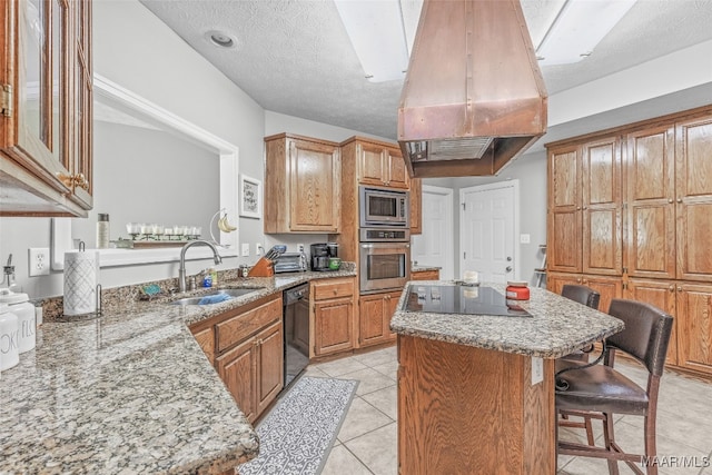 kitchen featuring black appliances, a breakfast bar, sink, custom exhaust hood, and a textured ceiling