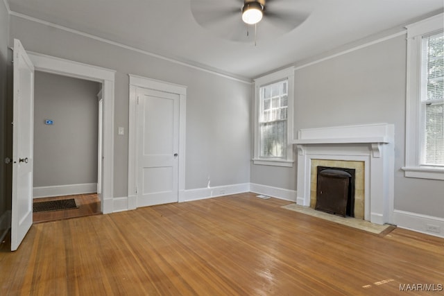 unfurnished living room with wood-type flooring, ceiling fan, and a healthy amount of sunlight