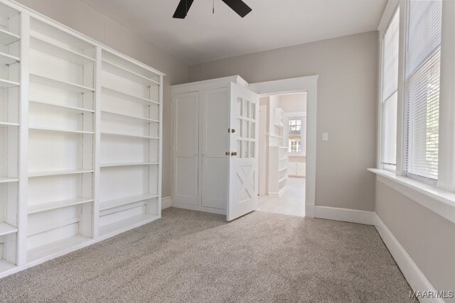 interior space featuring ceiling fan and light carpet