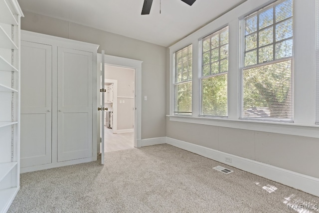 spare room with ceiling fan and light colored carpet