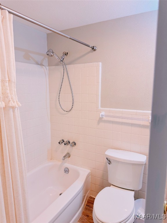 bathroom with hardwood / wood-style flooring, shower / tub combo, tile walls, and toilet