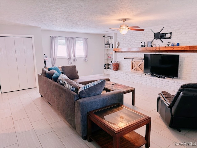 living room with ceiling fan, a textured ceiling, brick wall, and built in shelves