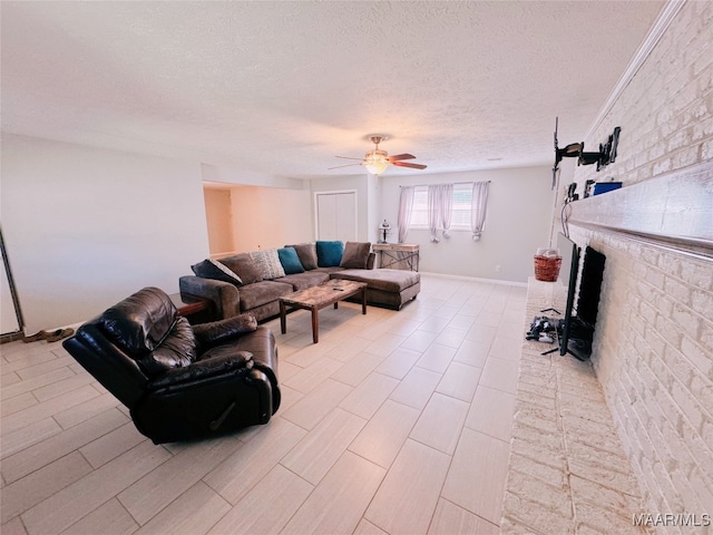 living room with ceiling fan, a brick fireplace, brick wall, a textured ceiling, and light wood-type flooring