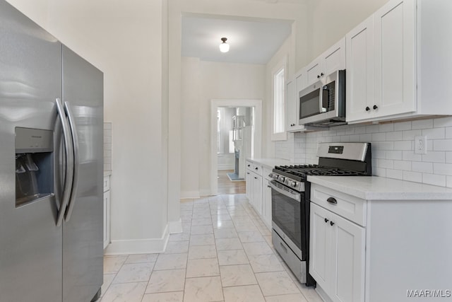 kitchen with decorative backsplash, white cabinetry, and stainless steel appliances