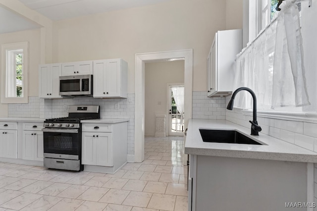 kitchen featuring stainless steel appliances, sink, and white cabinetry