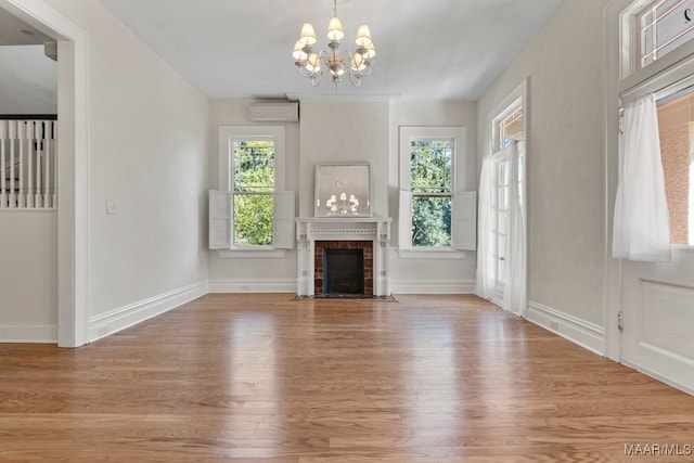 unfurnished living room featuring a notable chandelier, light wood-type flooring, and a fireplace