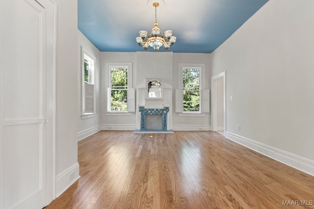 unfurnished living room featuring hardwood / wood-style floors and a chandelier