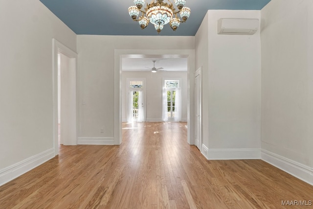 entryway featuring ceiling fan with notable chandelier, light hardwood / wood-style floors, and a wall mounted AC