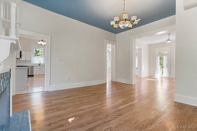 interior space featuring a healthy amount of sunlight, a wall unit AC, sink, and light hardwood / wood-style flooring