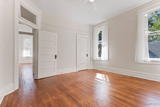 unfurnished room with ceiling fan, hardwood / wood-style flooring, and a healthy amount of sunlight