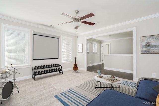 sitting room featuring carpet floors, ornamental molding, and ceiling fan