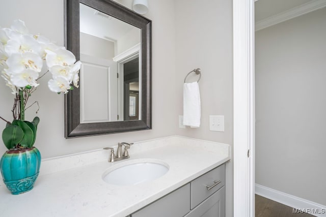 bathroom with wood-type flooring, crown molding, and vanity