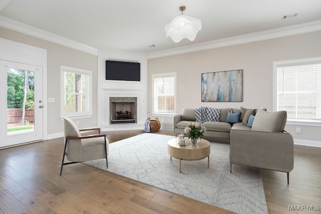 living room featuring ornamental molding, a healthy amount of sunlight, and dark wood-type flooring