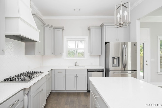 kitchen with custom exhaust hood, ornamental molding, sink, appliances with stainless steel finishes, and dark hardwood / wood-style flooring