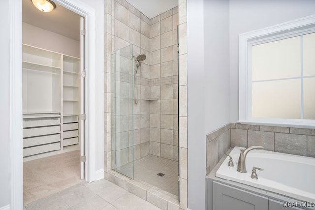 bathroom with tile patterned floors and shower with separate bathtub