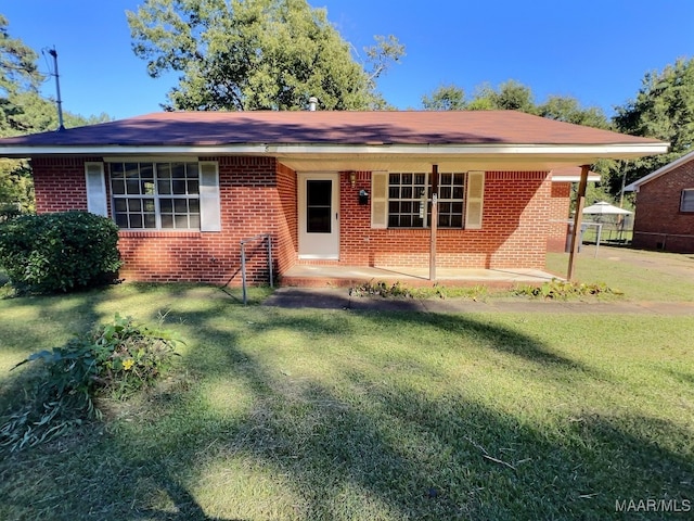 ranch-style home with a front lawn and a patio area