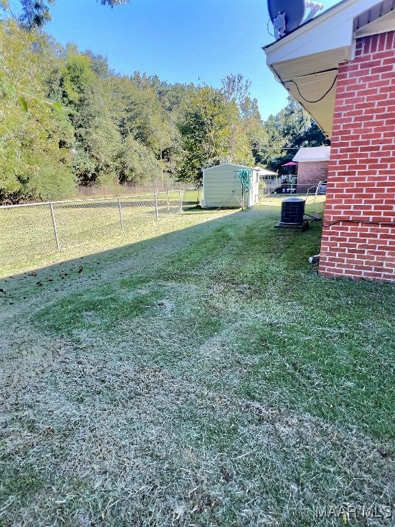 view of yard featuring a shed and central air condition unit