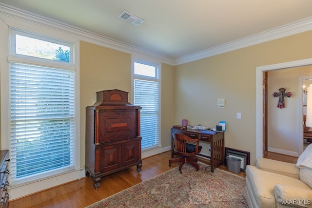 office area with plenty of natural light, ornamental molding, and light hardwood / wood-style flooring