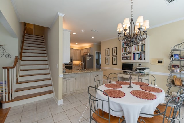 tiled dining area with an inviting chandelier, ornamental molding, and sink