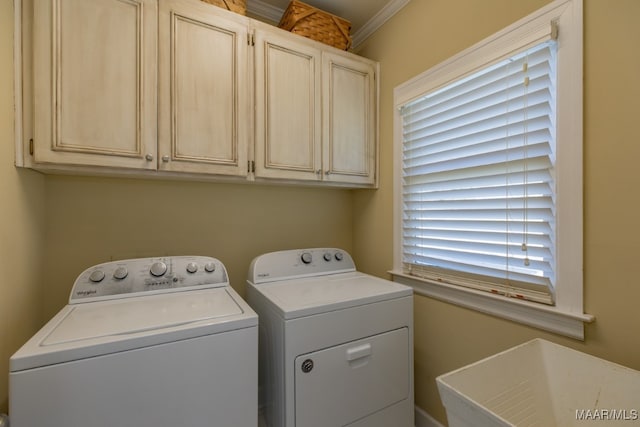 laundry room with ornamental molding, cabinets, washer and dryer, and a healthy amount of sunlight