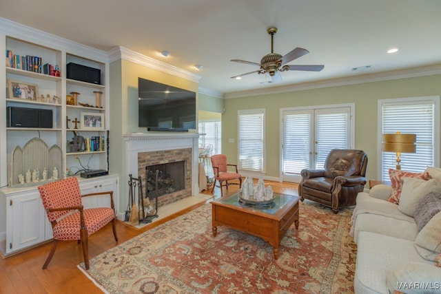 living room featuring ceiling fan, light hardwood / wood-style flooring, and crown molding