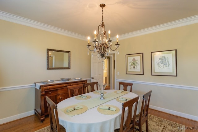 dining room featuring a notable chandelier, hardwood / wood-style flooring, and ornamental molding