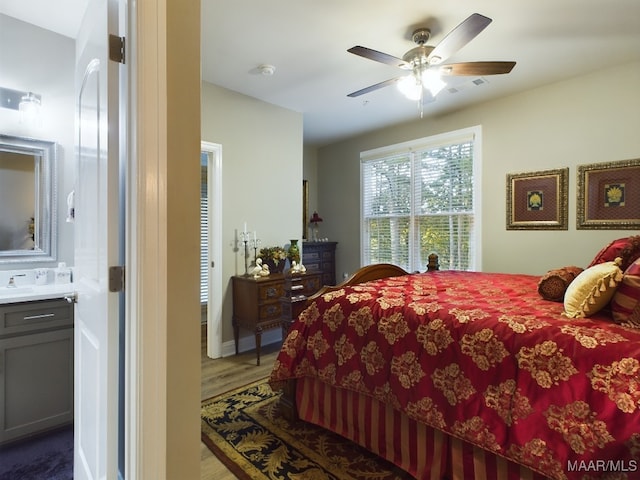 bedroom with sink, ensuite bathroom, wood-type flooring, and ceiling fan