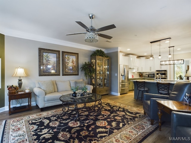 living room with crown molding, light wood-type flooring, and ceiling fan