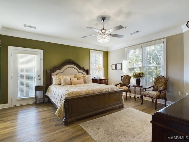 bedroom with dark wood-type flooring, ceiling fan, and ornamental molding