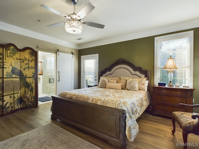 bedroom with ensuite bathroom, dark hardwood / wood-style floors, a barn door, and ceiling fan