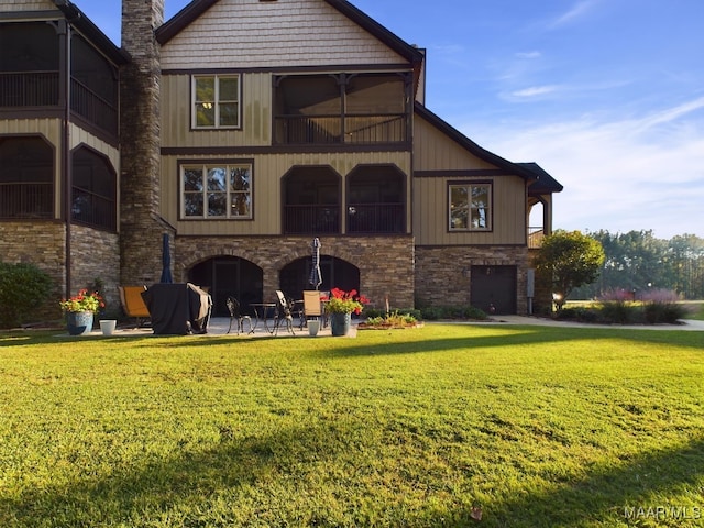 rear view of house with a yard, a patio, and a balcony