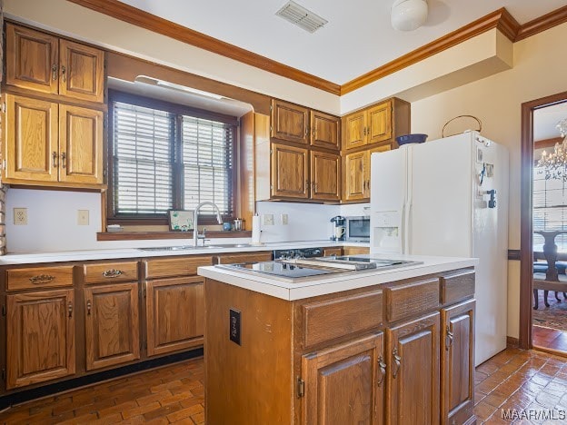 kitchen with white refrigerator with ice dispenser, a notable chandelier, sink, ornamental molding, and a center island