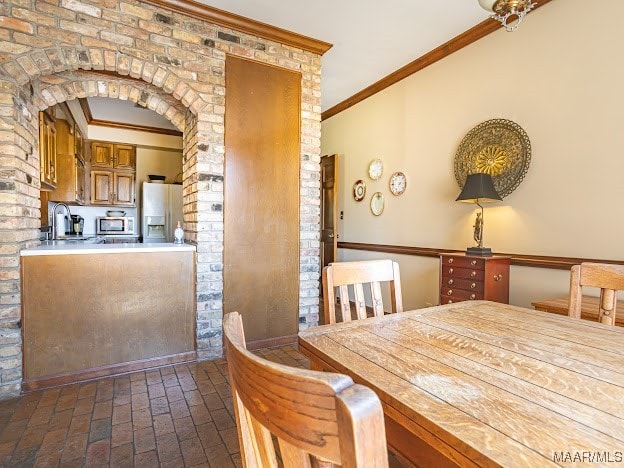 dining space with crown molding