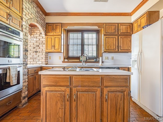 kitchen with appliances with stainless steel finishes, ornamental molding, and a kitchen island