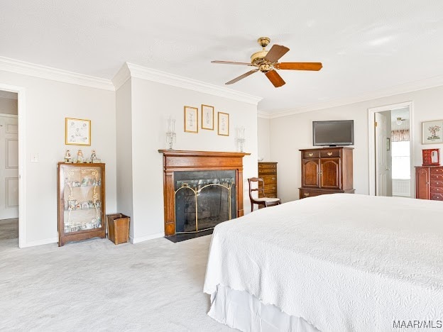 bedroom with ensuite bath, light carpet, crown molding, and ceiling fan