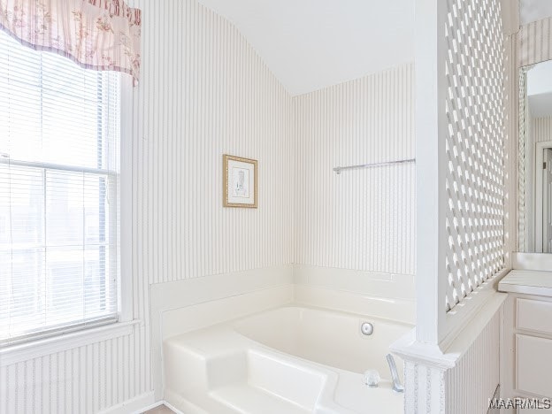 bathroom with a washtub and vanity