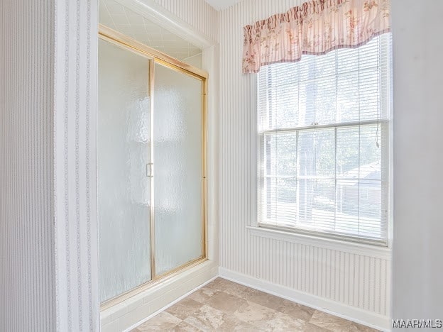 bathroom featuring an enclosed shower and a healthy amount of sunlight