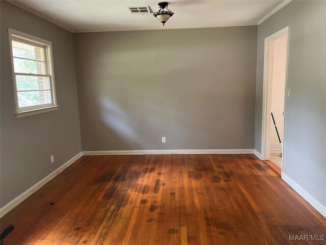 spare room featuring crown molding and dark hardwood / wood-style flooring